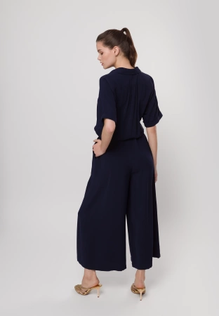 Granatowy kombinezon zapinany do pasa z szerokimi nogawkami