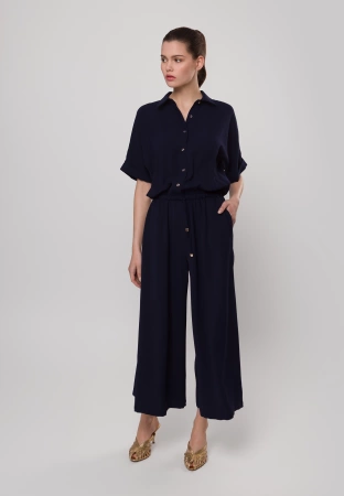 Granatowy kombinezon zapinany do pasa z szerokimi nogawkami