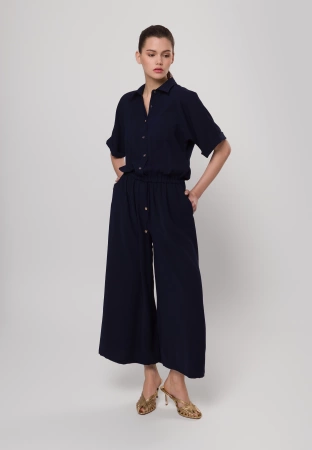 Granatowy kombinezon zapinany do pasa z szerokimi nogawkami
