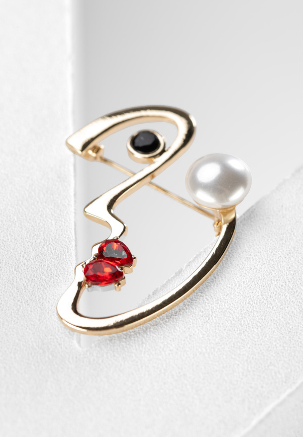 Broszka w kształcie twarzy