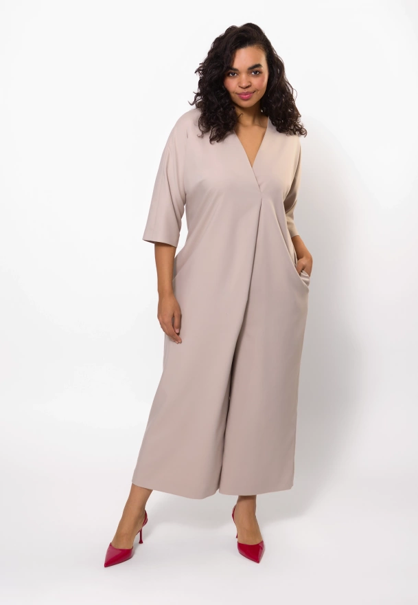 Beżowy kombinezon z asymetrycznym przodem o luźnej formie